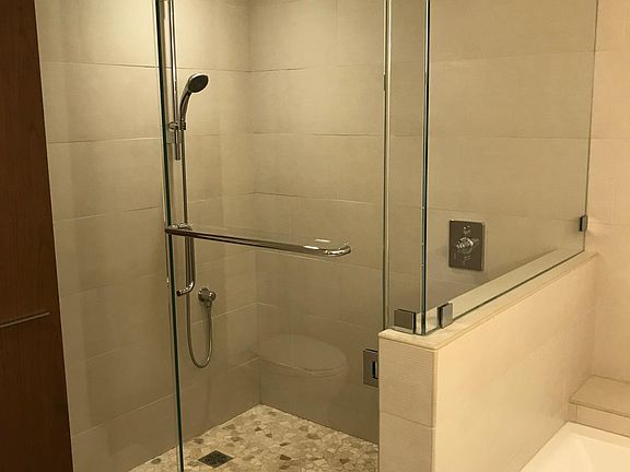 Large shower with wand and rain head.