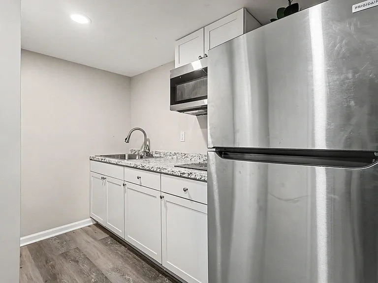 Efficient kitchen with stainless steel appliances, granite-look counters, ample cabinetry, and a convenient sink workspace.
