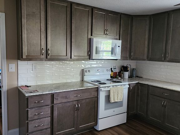 Kitchen stove and microwave. Misc on counter not included.