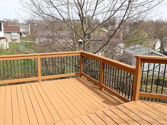 2-tier deck with metal railing overlooks beautiful yard
