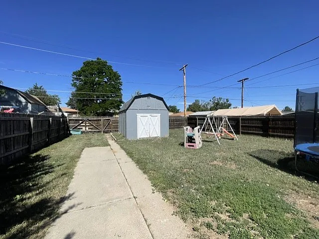 back yard showing double gate entrance from the ally, parking area and storage shed/workshop