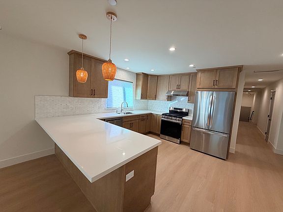 Gorgeous remodeled kitchen with quartz counter tops, custom cabinetry and stainless steel appliances