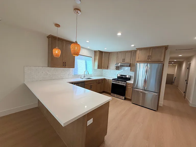 Gorgeous remodeled kitchen with quartz counter tops, custom cabinetry and stainless steel appliances