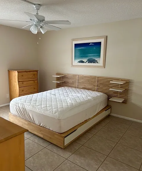 bedroom furnished with queen bed, two dressers and walk in closet