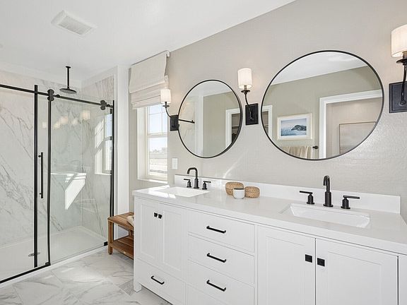 Primary bath with dual circular mirrors and matte black fixtures