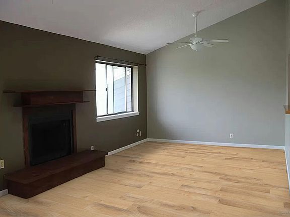 Living and dining area with vaulted ceiling and skylight (rending of solid surface flooring to be installed prior to lease)