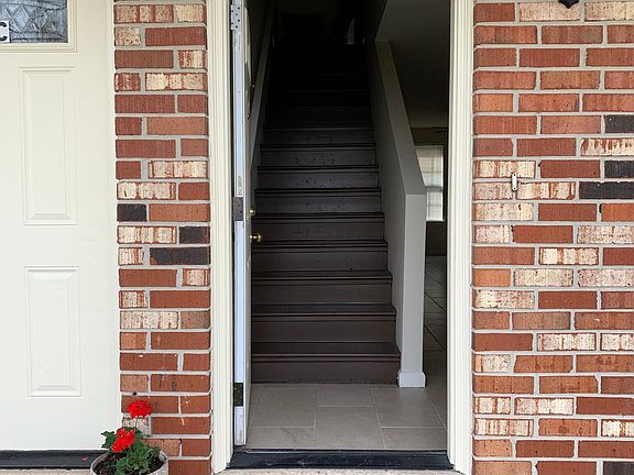 Open the door to wooden stairs on left and living room on right.