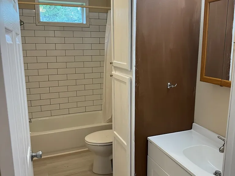 New hall bath vanity, cabinet, toilet, tub and tile shower enclosure. And new floor