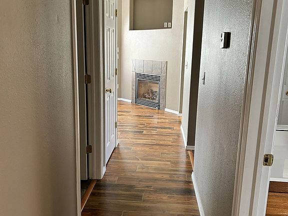 Hallway from primary suite to laundry room on left and kitchen on right