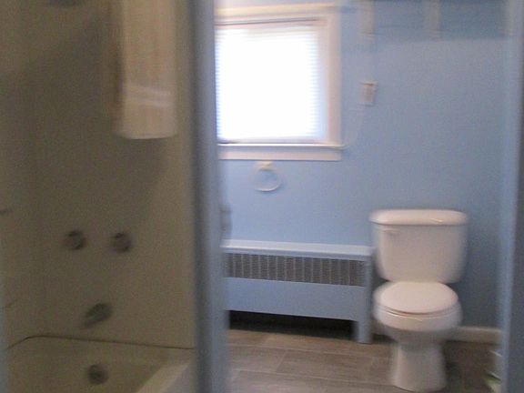 Bathroom, there is a linen closet on left of tub and to the right by the toilet is a vanity with mirror over head