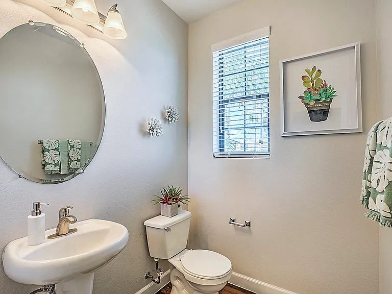 Refresh in style at The Michael B's updated guest bathroom, featuring a crisp white sink and toilet bathed in natural light.