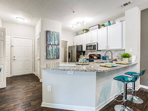 Kitchen featuring large granite counter tops and white cabinets.