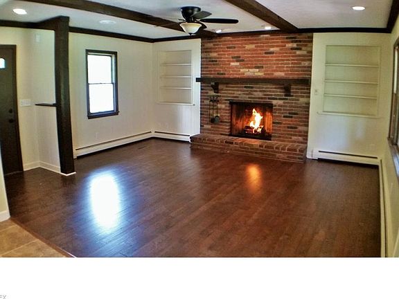 Den opens to the kitchen to create a hearth room.  Brick fireplace with gas insert, solid hand scraped hardwood flooring, beamed ceilings, recessed lighting
