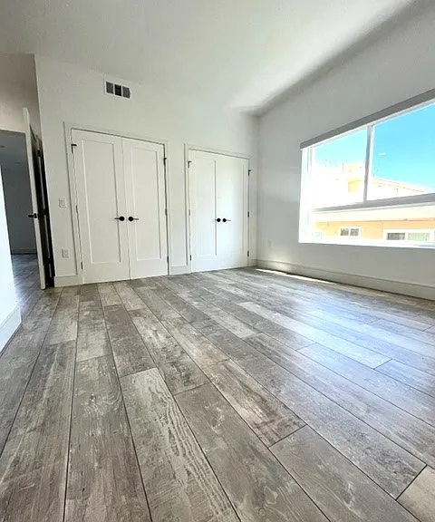 Large primary bedroom with built ins inside closet and tons of bright light
