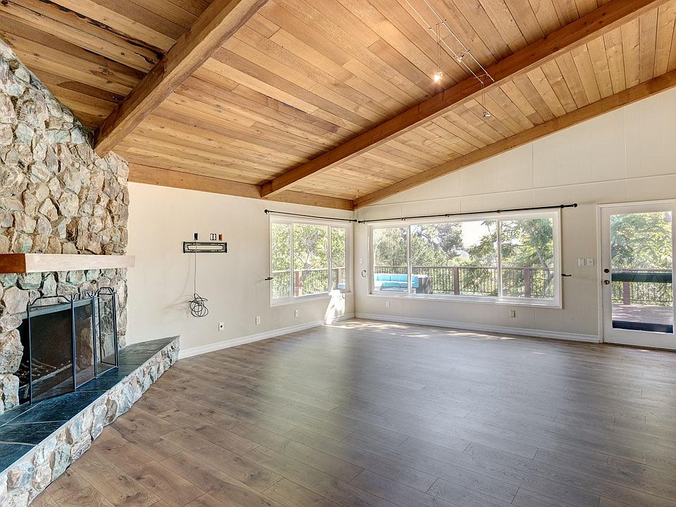 Cabin-style living room featuring a large wood fireplace.