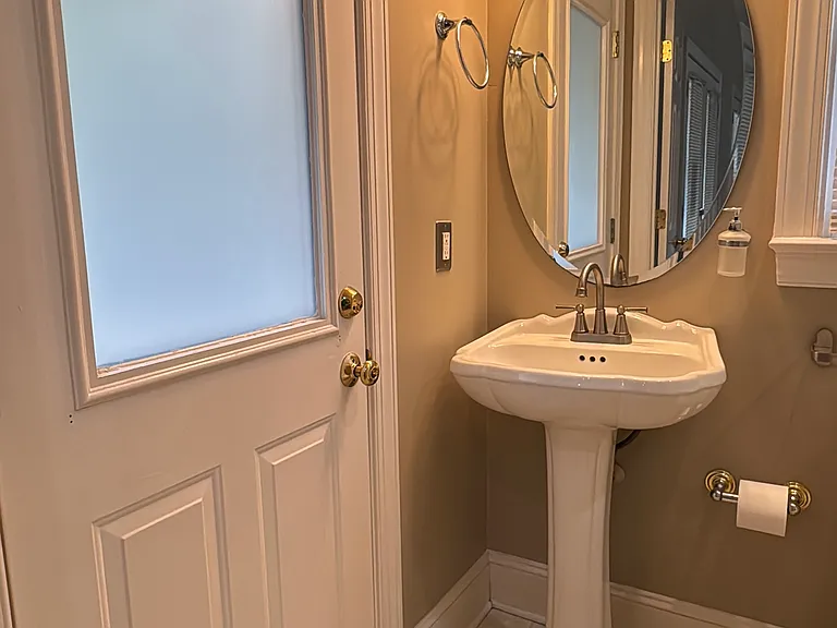 Private full bathroom with vanity mirror, clean and bright finishes.