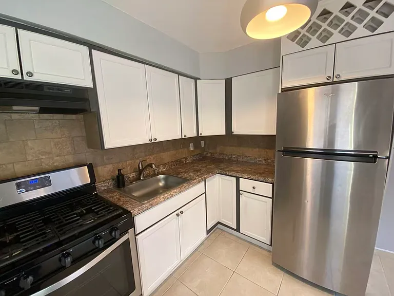 Bright and functional kitchen on the first floor featuring stainless steel appliances, ample cabinet storage, generous counter space, and a gas range.