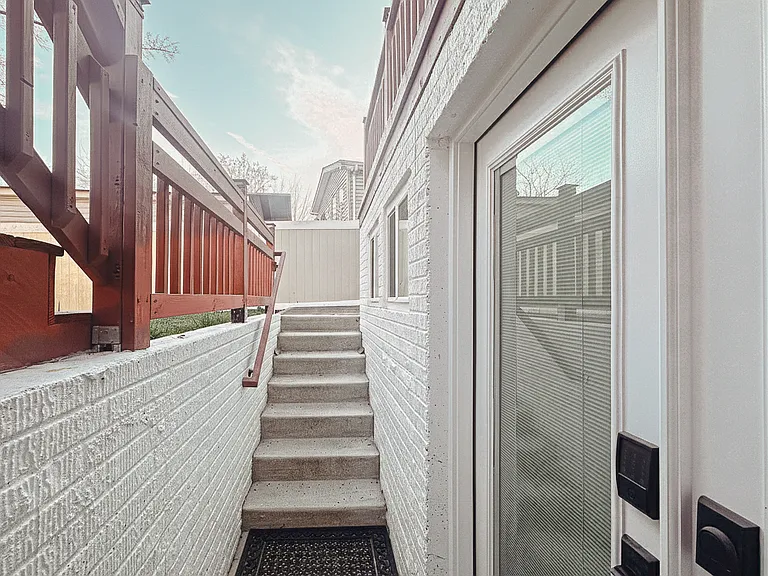 Exterior entry view showing the private French doors and covered access beneath the deck.
