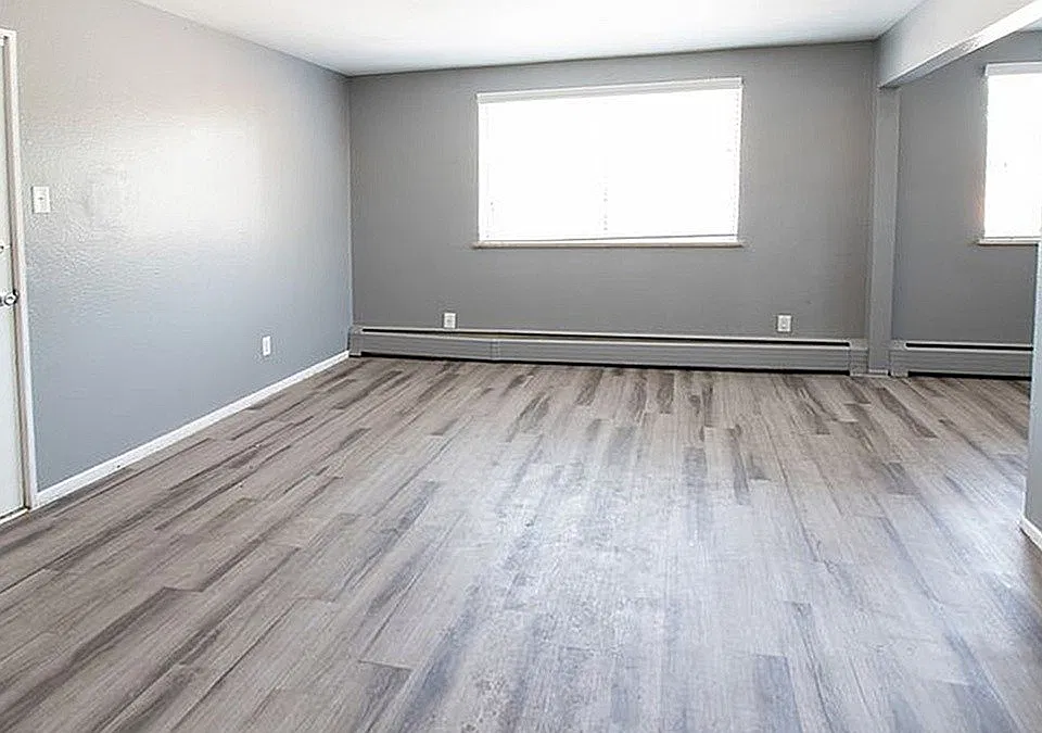 Bright and spacious living area with sleek gray flooring and modern neutral walls, perfect for stylish urban living.