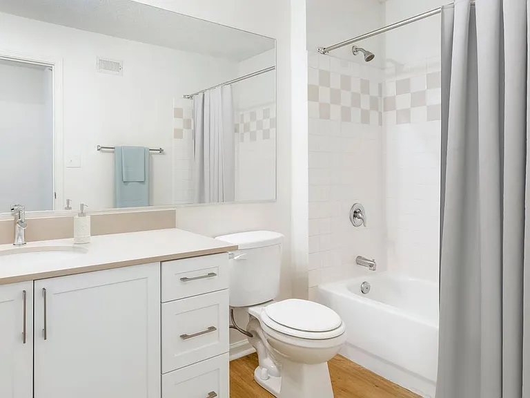Renovated Package I bath with white cabinetry, beige quartz countertops, and hard surface flooring