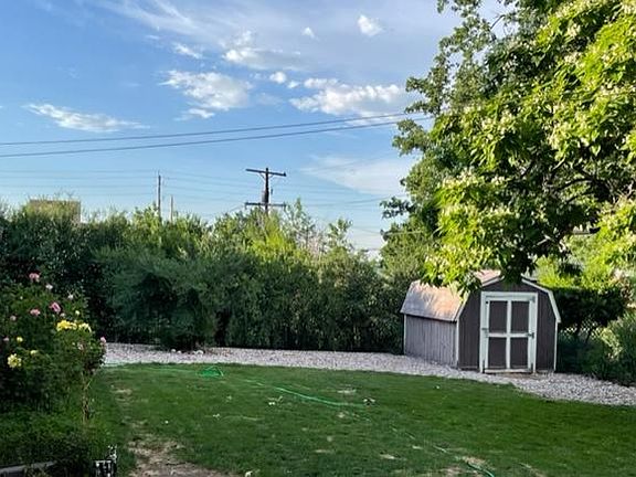 Fully fenced back yard with large shed and mature landscaping and trees.