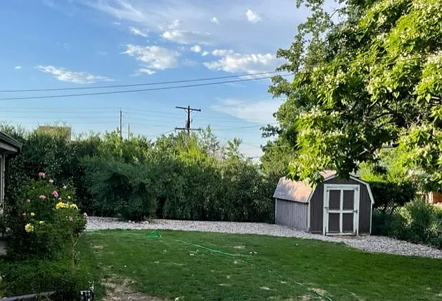 Fully fenced back yard with large shed and mature landscaping and trees.