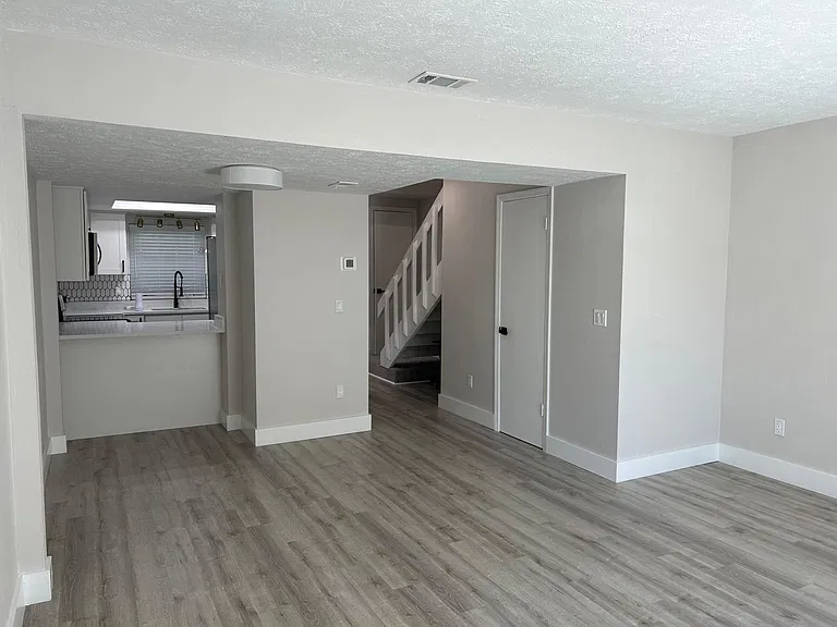 View of Kitchen, Dining Nook, Door to Downstairs Bathroom from Living Room Area