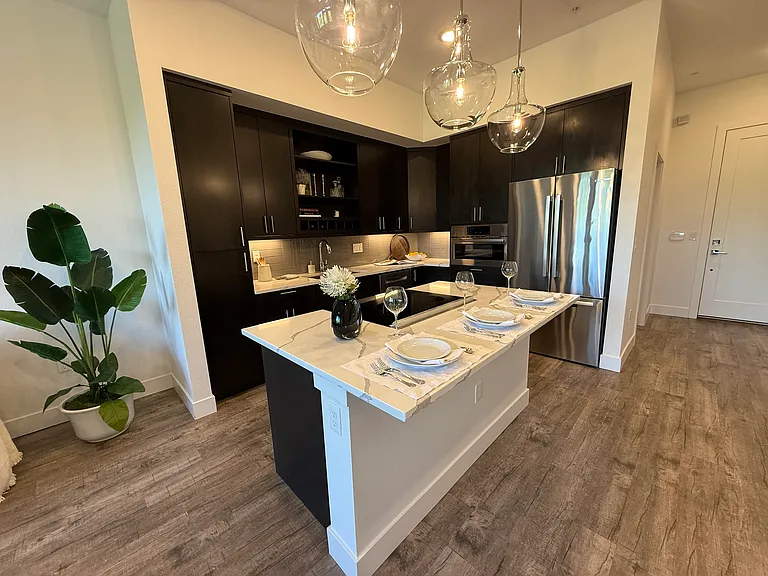 Large kitchen island, double door refrigerator with a lower freezer drawer and high-end Bosch appliances.