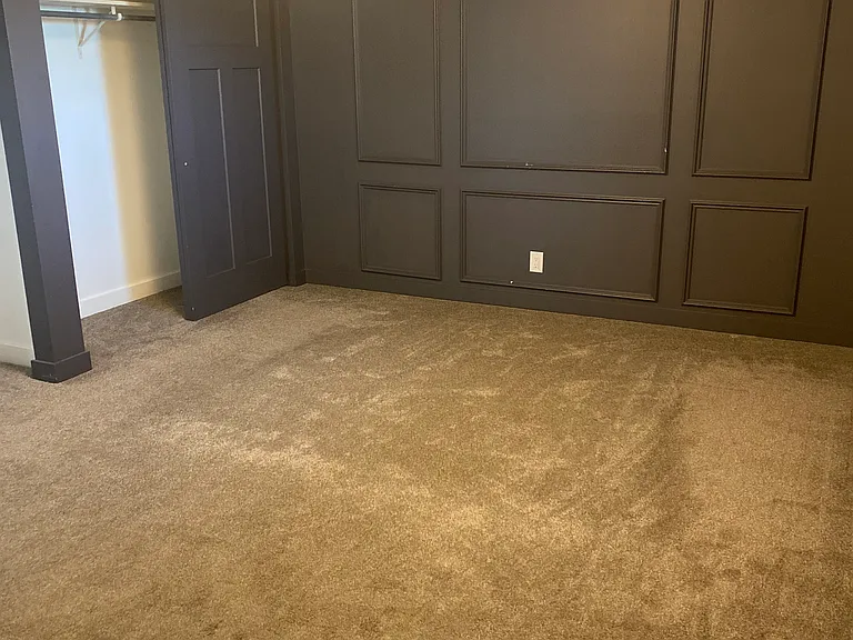 Master bedroom with rich green/grey board and batten. Double closets.