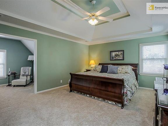 Large master bedroom with tray ceiling and sitting room.
