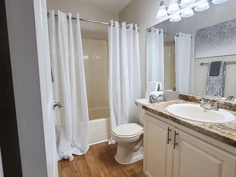 Traditional bathrooms that pamper you with wood-style floors, granite-style countertops, and generous mirrors.
