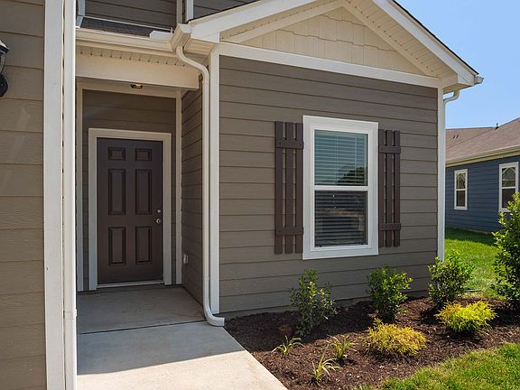 Enjoy a charming front porch and professional front yard landscaping.