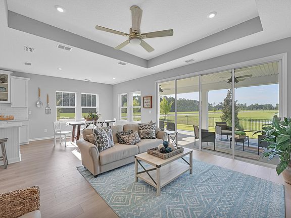family room with tray ceiling and sliding glass door