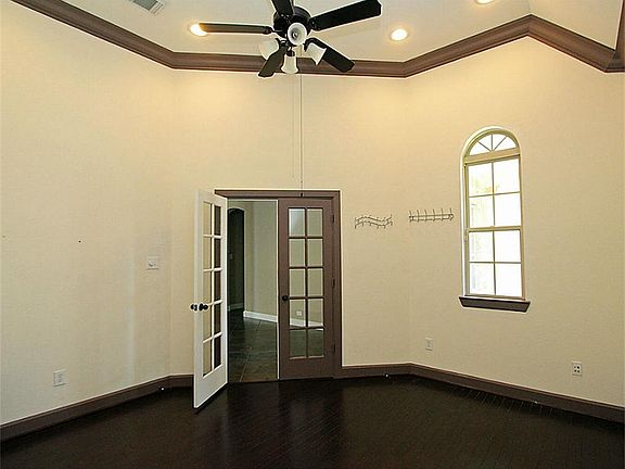 The study with stained crown molding and French door has hardwood floors and is at the front of the house.