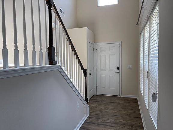 Two-story foyer entry with staircase and tall windows