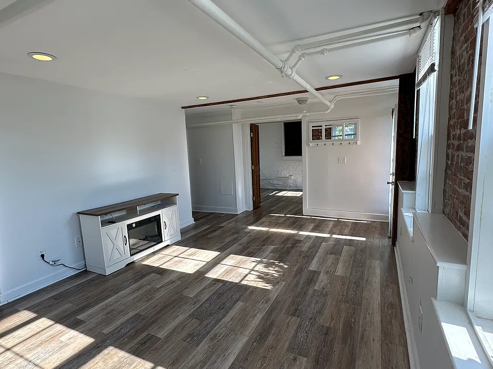 Living room facing bedroom with electric fireplace TV unit.