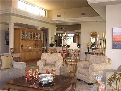 View from living room to dining room and kitchen. Celestory windows, built in two-sided hutch with granite sideboard and ample storage. Step down wet bar in corner of living area with wine cooler, ice maker and granite counters.