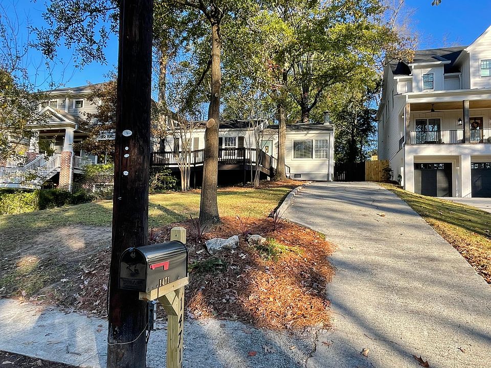 Front of home with large porch and private driveway. Room for 3 vehicles, one of which is behind backyard fence on parking pad.