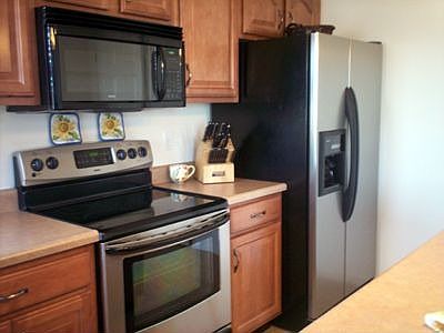 Beautiful raised panel maple cabinets and stainless steel appliances