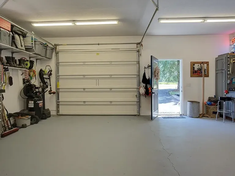 Oversized one car garage with man door entrance with work bench and lots of cabinet space for all those projects!