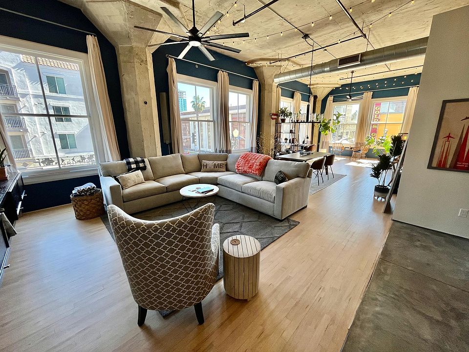 Living area with maple hardwood floors, 13' ceilings, and double hung windows.