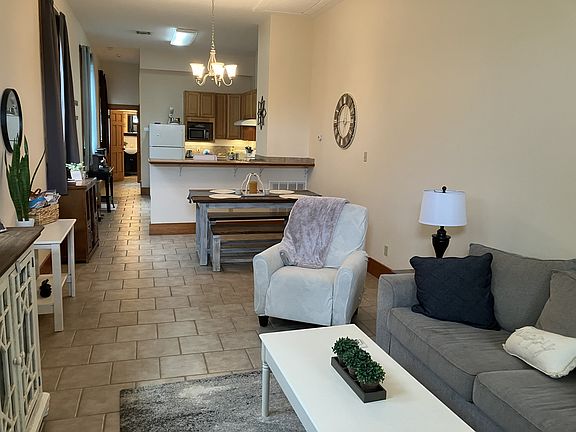 Open plan living and dining room with kitchen separated with bar top.