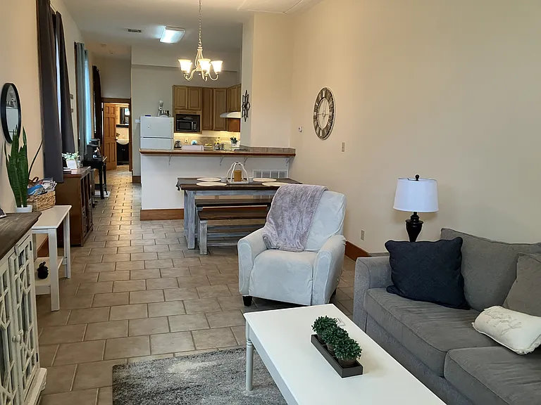 Open plan living and dining room with kitchen separated with bar top.