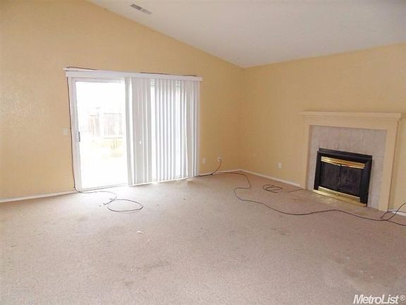 Living room with vaulted ceiling, fireplace and slider to the backyard