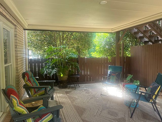 Private covered patio with rug and furniture