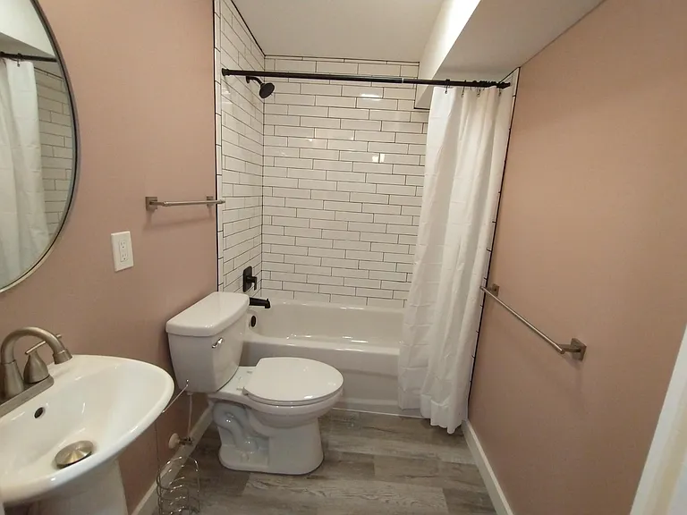 Hallway bathroom with matte black tub fixtures