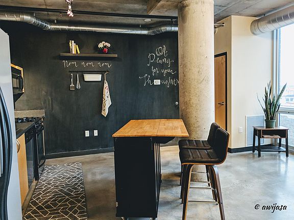 Open space living area and small dining area with chalkboard wall.