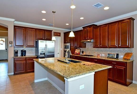 Stainless appliances and gas cooking add a gourmet touch to the kitchen. Also, notice the crown molding present throughout the home, even in the kitchen.