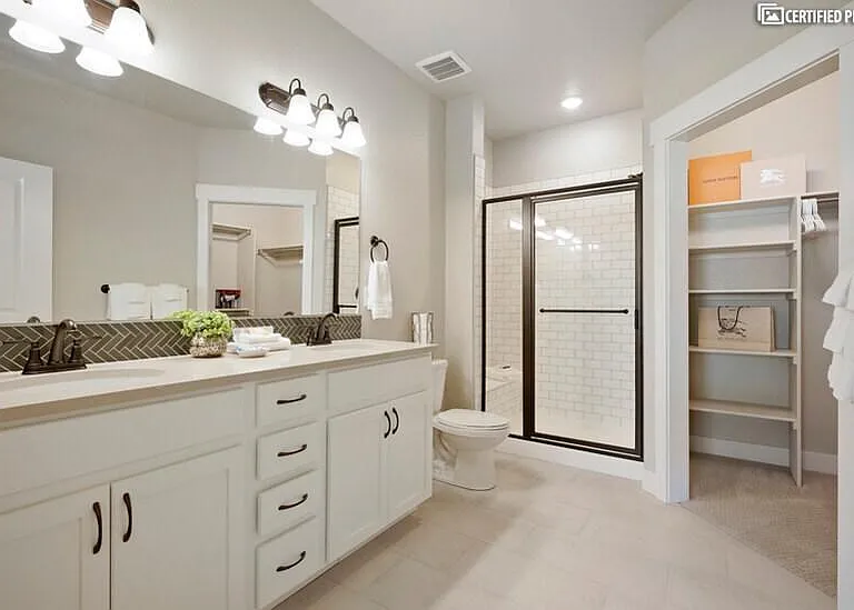 Master bathroom with double sinks and walk-in tile shower