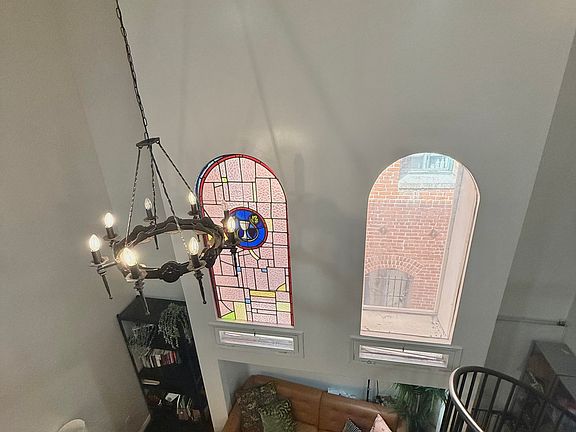 Original stain glass window with high cathedral ceilings with custom gothic chandelier